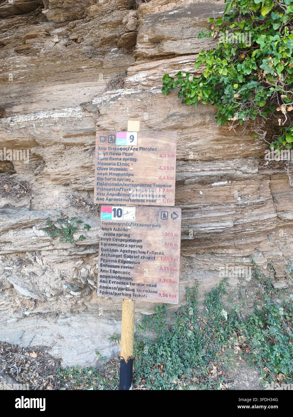 Holzschilder des Wanderwegs an einer Felswand im Dorf Strapouries auf Andros Stockfoto