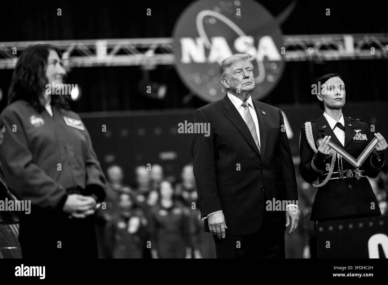 Präsident Donald J. Trump steht während der Congressional Space Medal of Honor Zeremonie im Johnson Space Center der NASA in Houston, Texas, am 28. August 2026, wobei die Artemis-II-Astronautin Christina Koch links zu sehen ist und ein US-Militäroffizier rechts eine Medaillenpräsentationstasche hält. Bild mit freundlicher Genehmigung des Weißen Hauses. Stockfoto