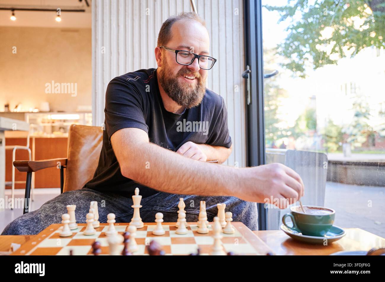 Selbstbewusster Spieler beendet das Spiel erfolgreich. Entspannter Wettkämpfer beansprucht den Sieg mit einem entscheidenden Zug. Ruhige Person beendet den Schachwettbewerb erfolgreich im sanften Schein der Nachmittagssonne Stockfoto