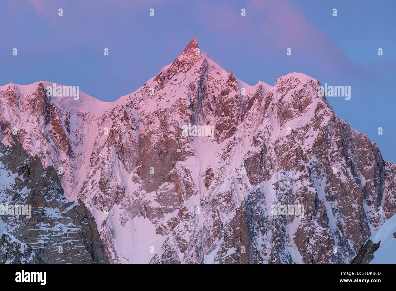Blick auf den Massiccio del Monte Bianco, der bei Sonnenuntergang in Valle d'Aosta, Italien, mit rosa Alpenglühlicht bedeckt ist. Stockfoto