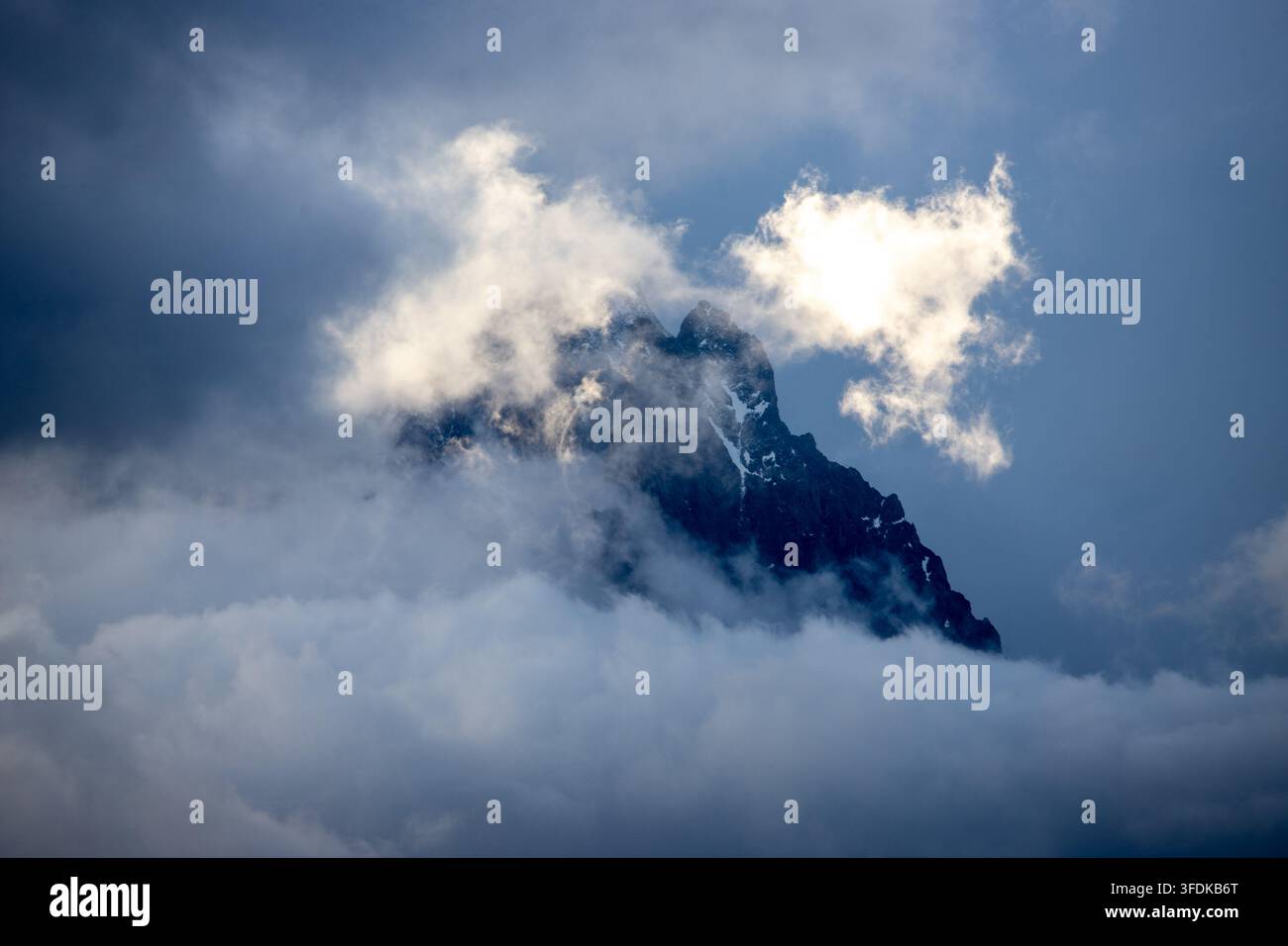 Blick auf den Gipfel des Massiccio del Monte Bianco, teilweise verdeckt von dicken Wolken und Nebel in der Alpenlandschaft des Aostatal, Italien. Stockfoto