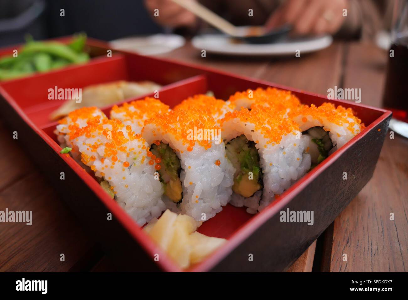 Sushi in einem Restaurant an einem Holztisch genießen Stockfoto