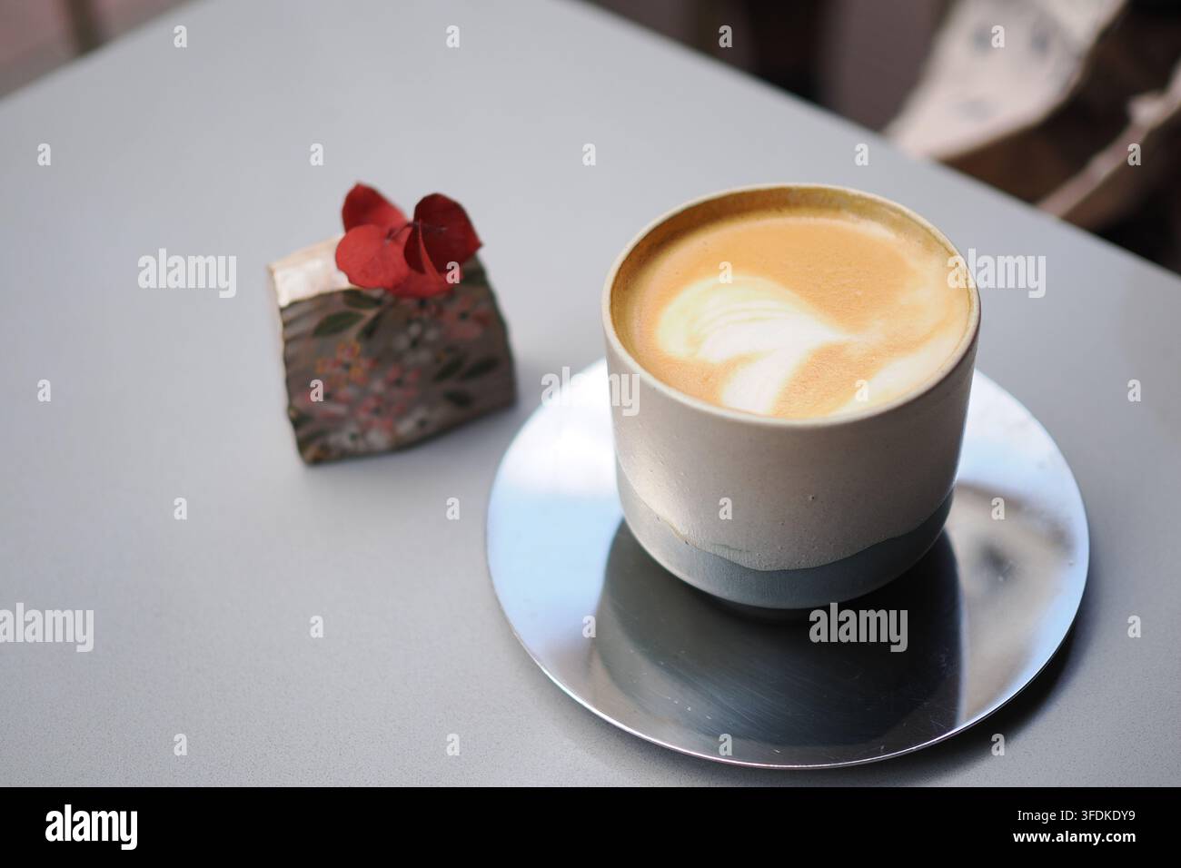 Kaffee mit einem kleinen Dessert auf einem Tisch Stockfoto