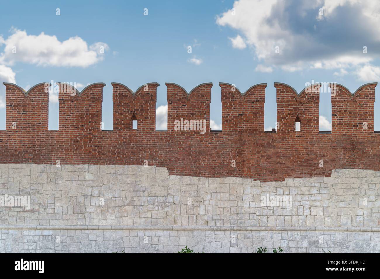 Besucher bewundern das markante Ziegelwerk der antiken Mauern des Tula-Kreml-Museums, wo Geschichte auf Kunst trifft vor einem lebendigen blauen Himmel, der mit Wolken übersät ist. Stockfoto
