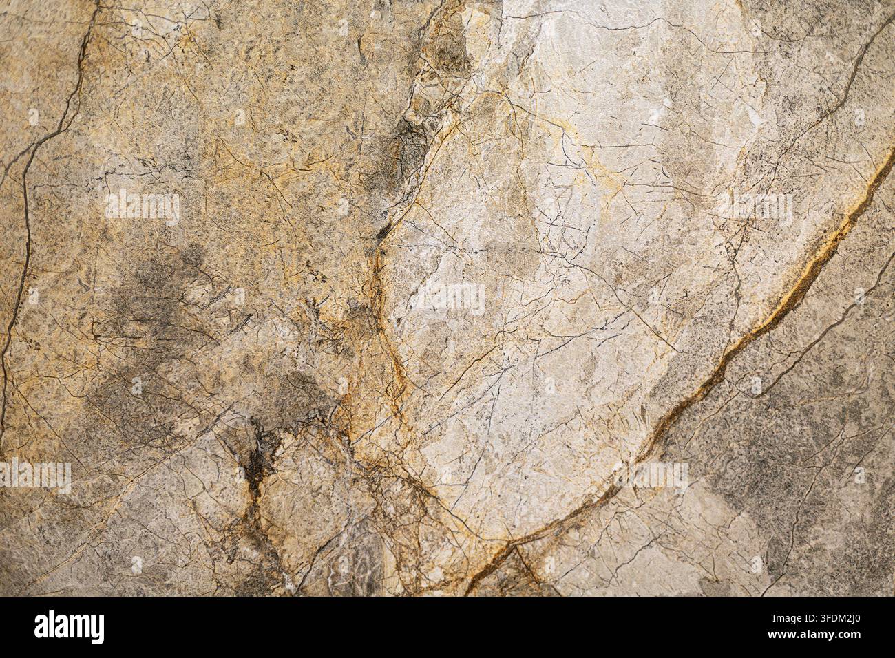 Beige und graue Marmorsteintextur. Nahaufnahme von beige und grauem Marmor mit natürlichen goldenen Adern, feinen Rissen, gesprenkelten Mineralmustern und verwitterten Stockfoto