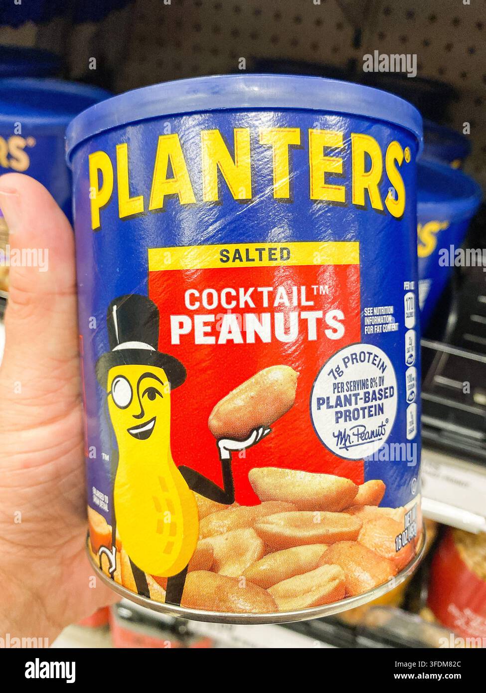 Eine Hand hält eine blaue Dose Planters Salted Cocktail Peanuts mit Mr. Peanut-Illustration. - Auburn WA USA - August,21 2026 Stockfoto