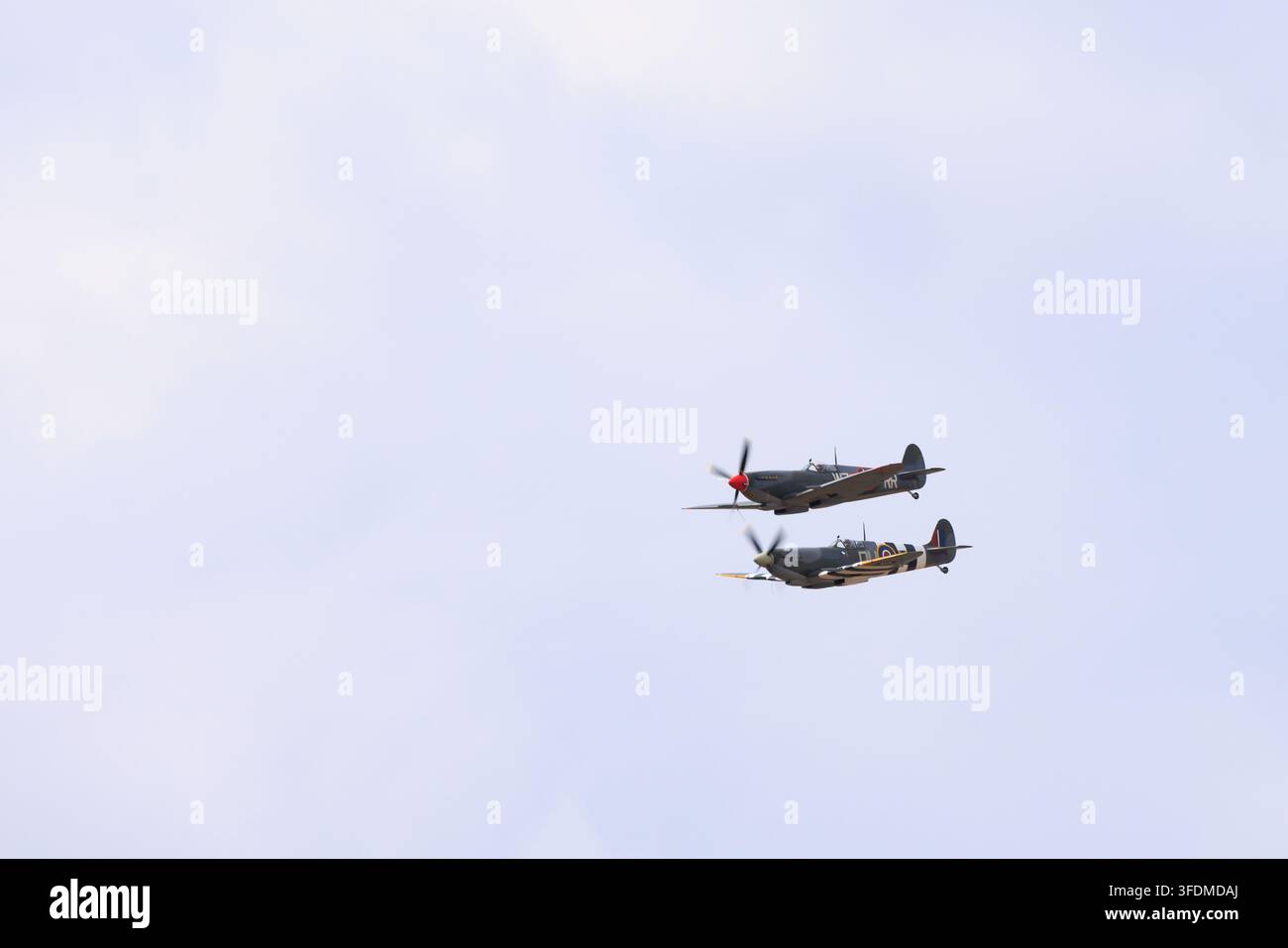 Zwei Supermarine Spitfires fliegen in enger Formation während einer Flugschau, darunter die Spitfire XVIe WZ-RR. Stockfoto