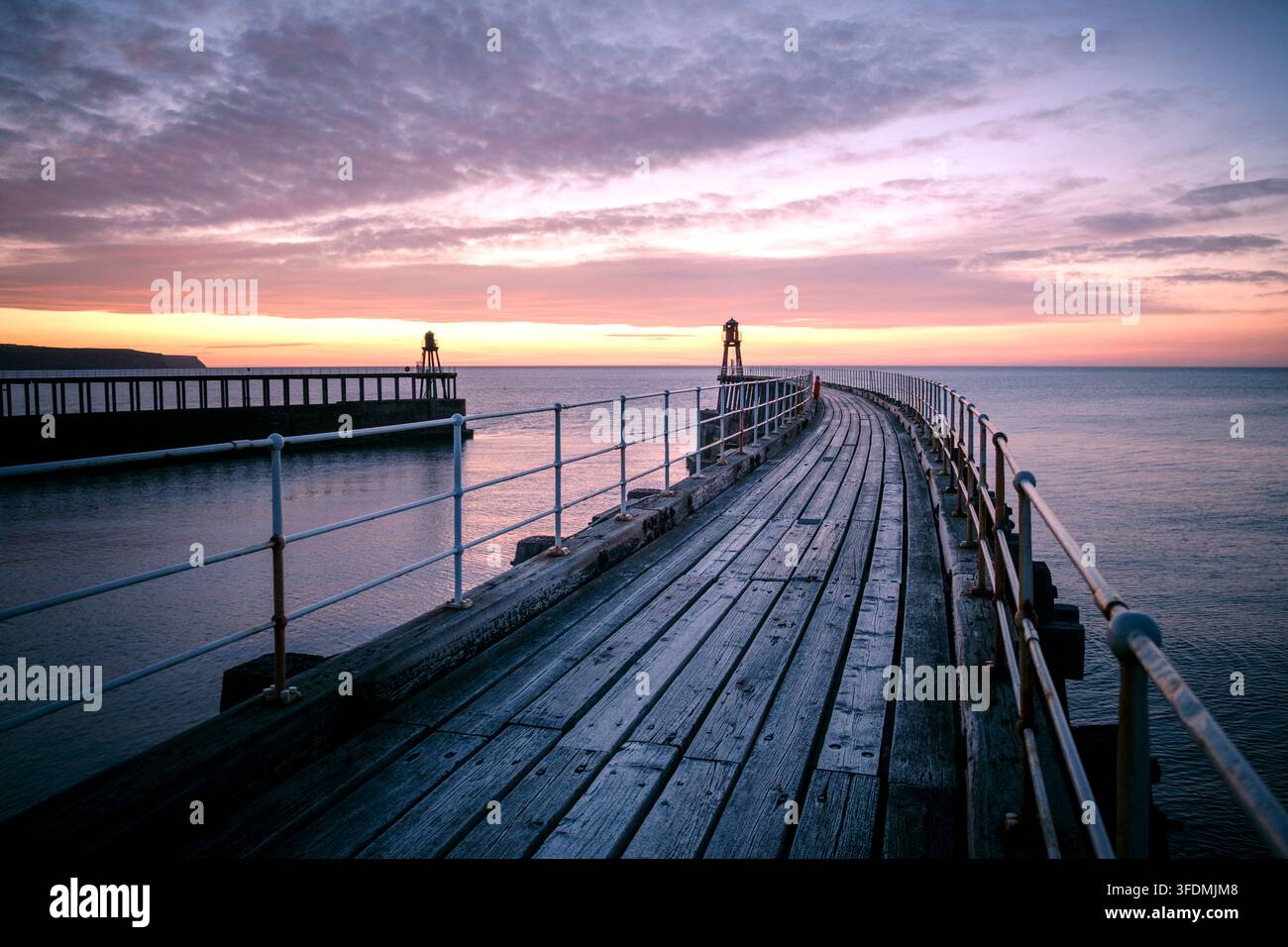 Sonnenuntergang über dem Ostpier von Whitby, North Yorkshire Stockfoto