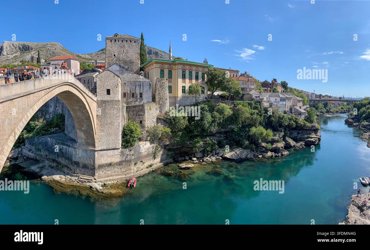 Panorama der Stari Most-Steinbogenbrücke über die Neretva, umgeben von historischen Türmen und Gebäuden aus der osmanischen Zeit, Altstadt von Mostar, Bosnien-Herzegowina - Smartphone-aufgenommenes Stockfoto