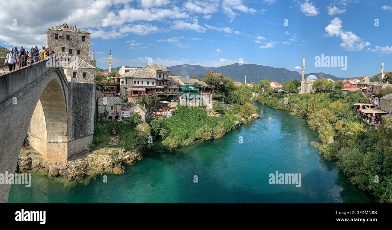 Panorama der Stari Most-Steinbogenbrücke über die Neretva, umgeben von historischen Türmen und Gebäuden aus der osmanischen Zeit, Altstadt von Mostar, Bosnien-Herzegowina - Smartphone-aufgenommenes Stockfoto