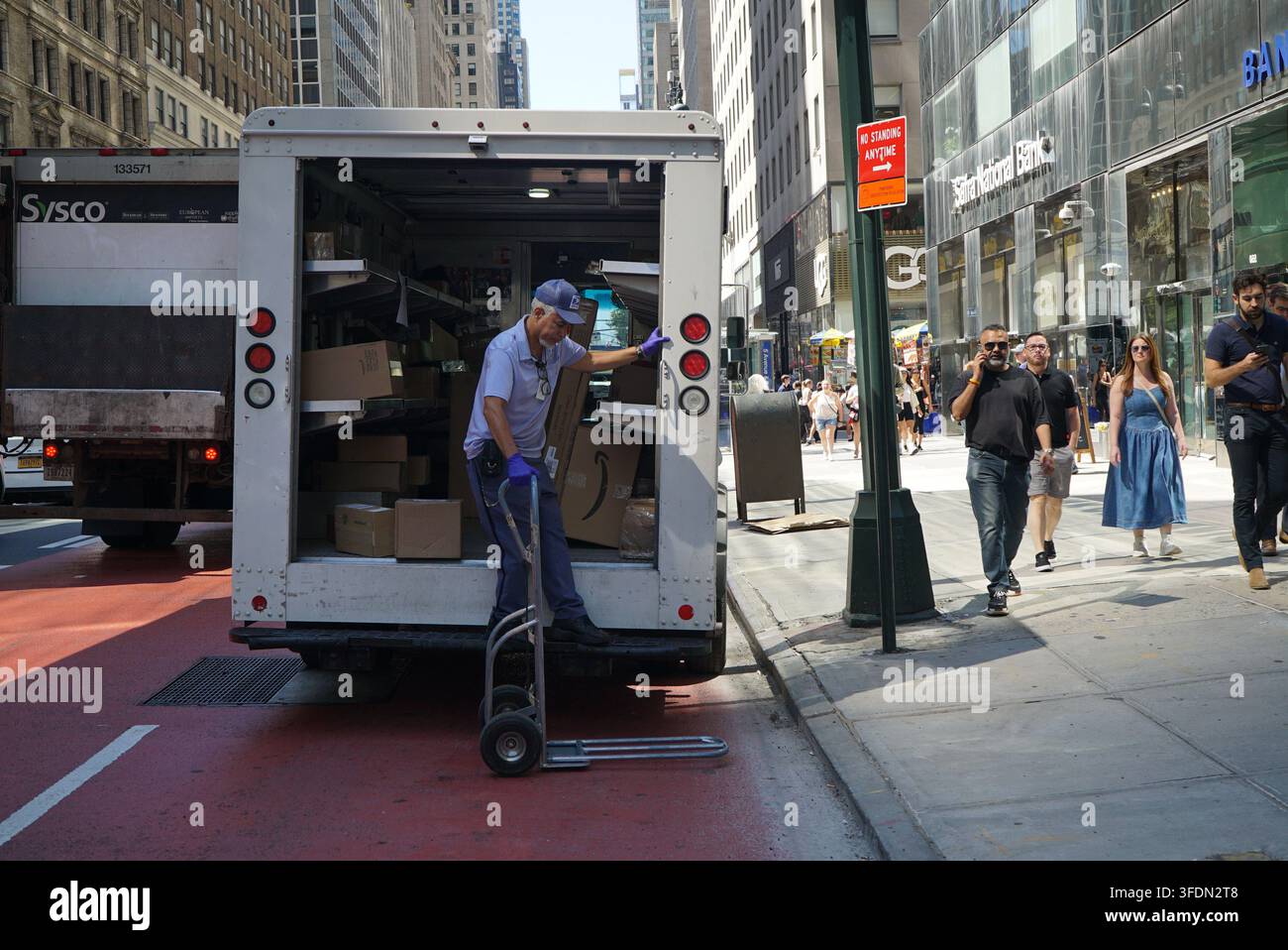 New York, New York, USA: Ein USPS-Postarbeiter lädt Pakete von einem Lieferwagen des United States Postal Service ab. Stockfoto