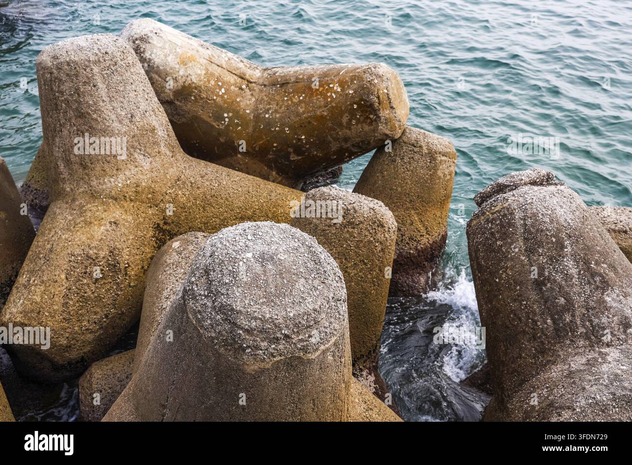 Beton-Tetrapoden bilden einen robusten Wellenbrecher, der die Küste vor Meereswellen und Erosion schützt Stockfoto