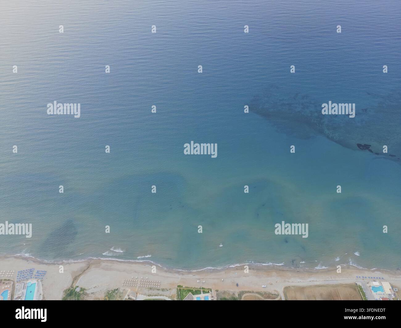 Luftbilddrohnenaufnahme des Meeres, des Strandes und der einzigartigen Wellenmuster auf der Wasseroberfläche, die die natürliche Schönheit der Mittelmeerküste auf Kreta zeigt Stockfoto