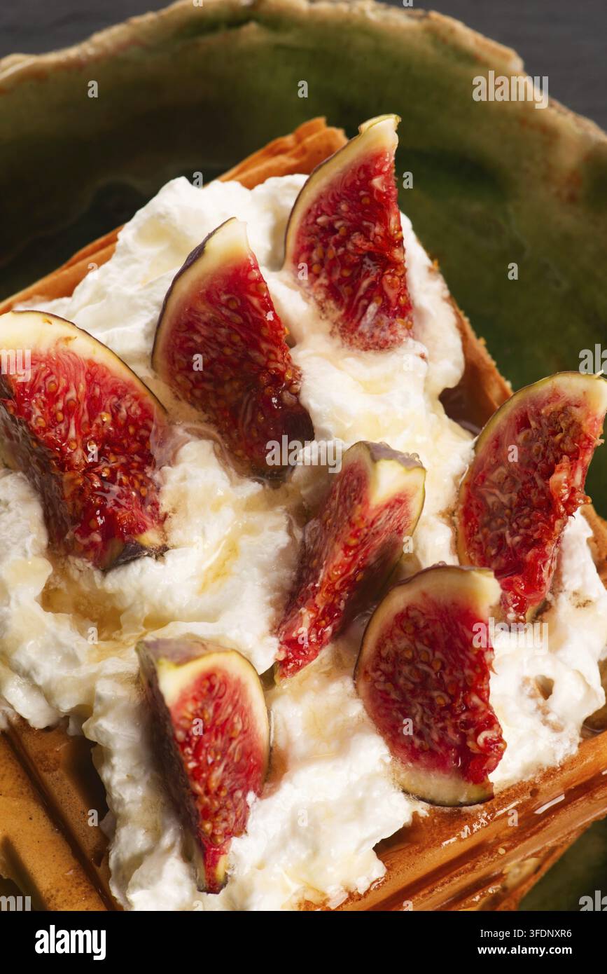 Waffeln mit Feigen, Ahornsirup, oben mit Schlagsahne Stockfoto