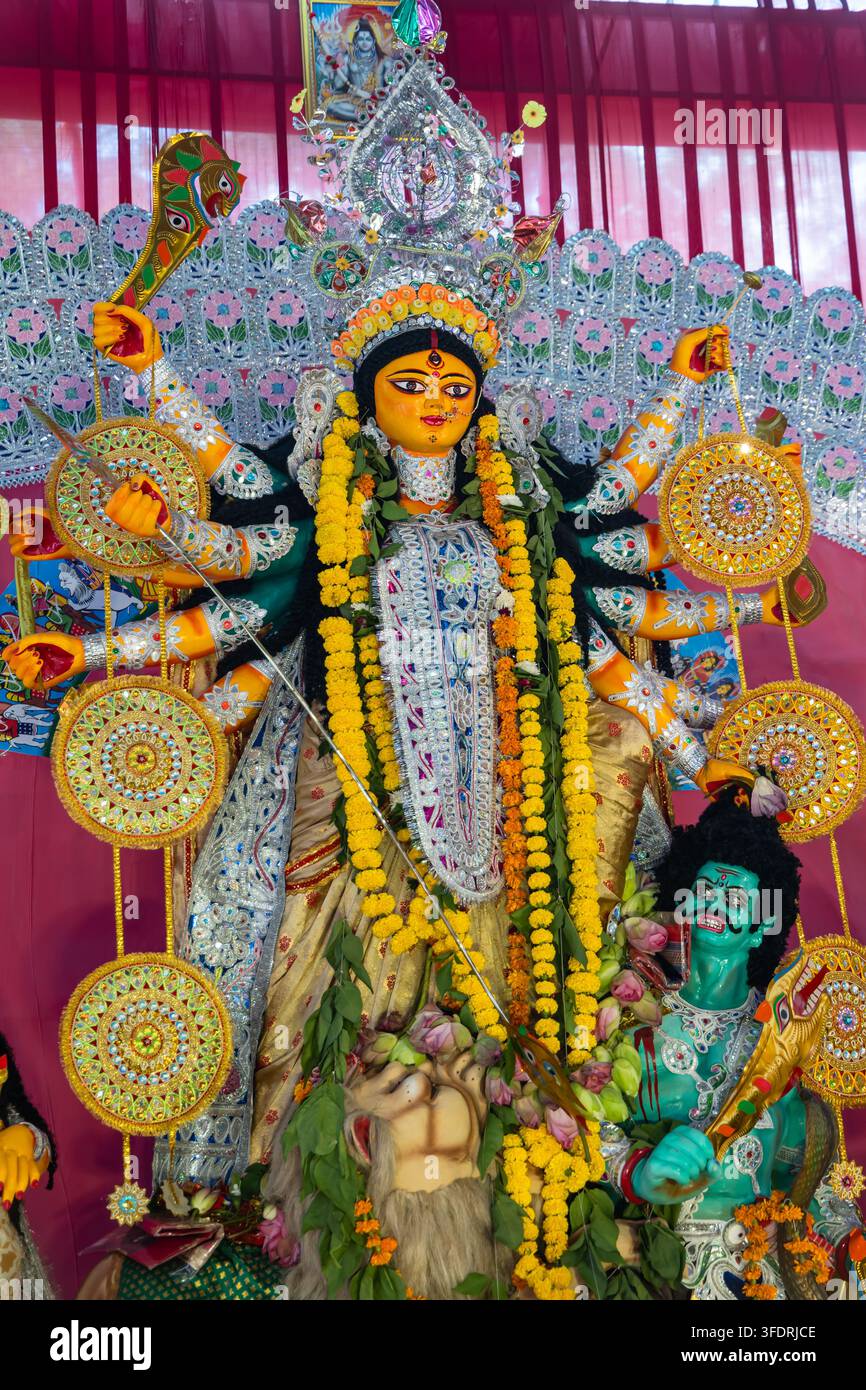 Hinduistische Göttin Durga Idol mit traditionellen Waffen und aufwendigem dekorativem Hintergrund anlässlich Dussehra Stockfoto
