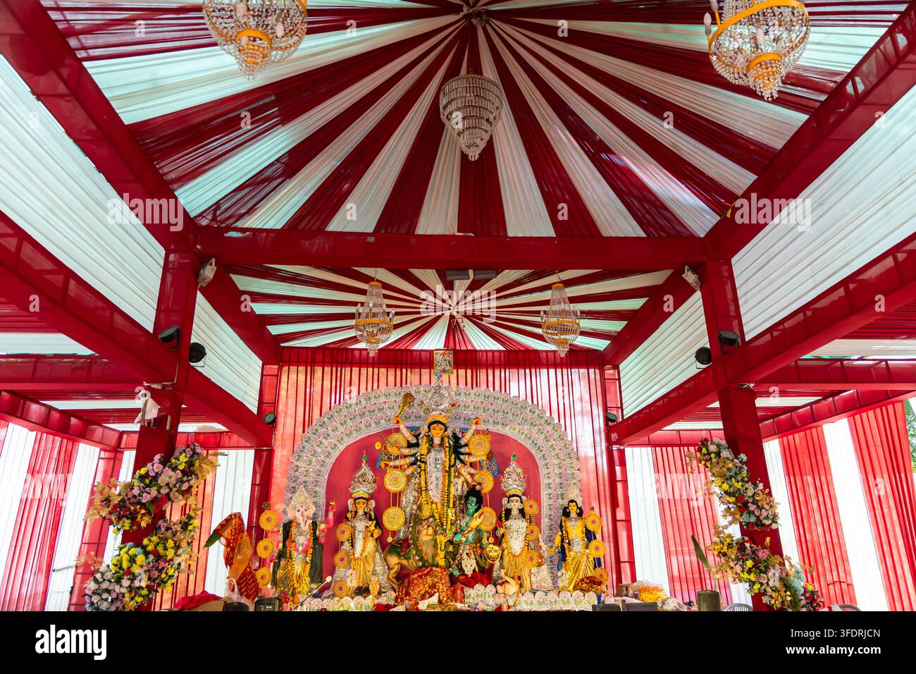 Lebhaftes Durga Puja Pandal-Interieur mit aufwendigen religiösen Dekorationen und Durga Puja-Idol Stockfoto