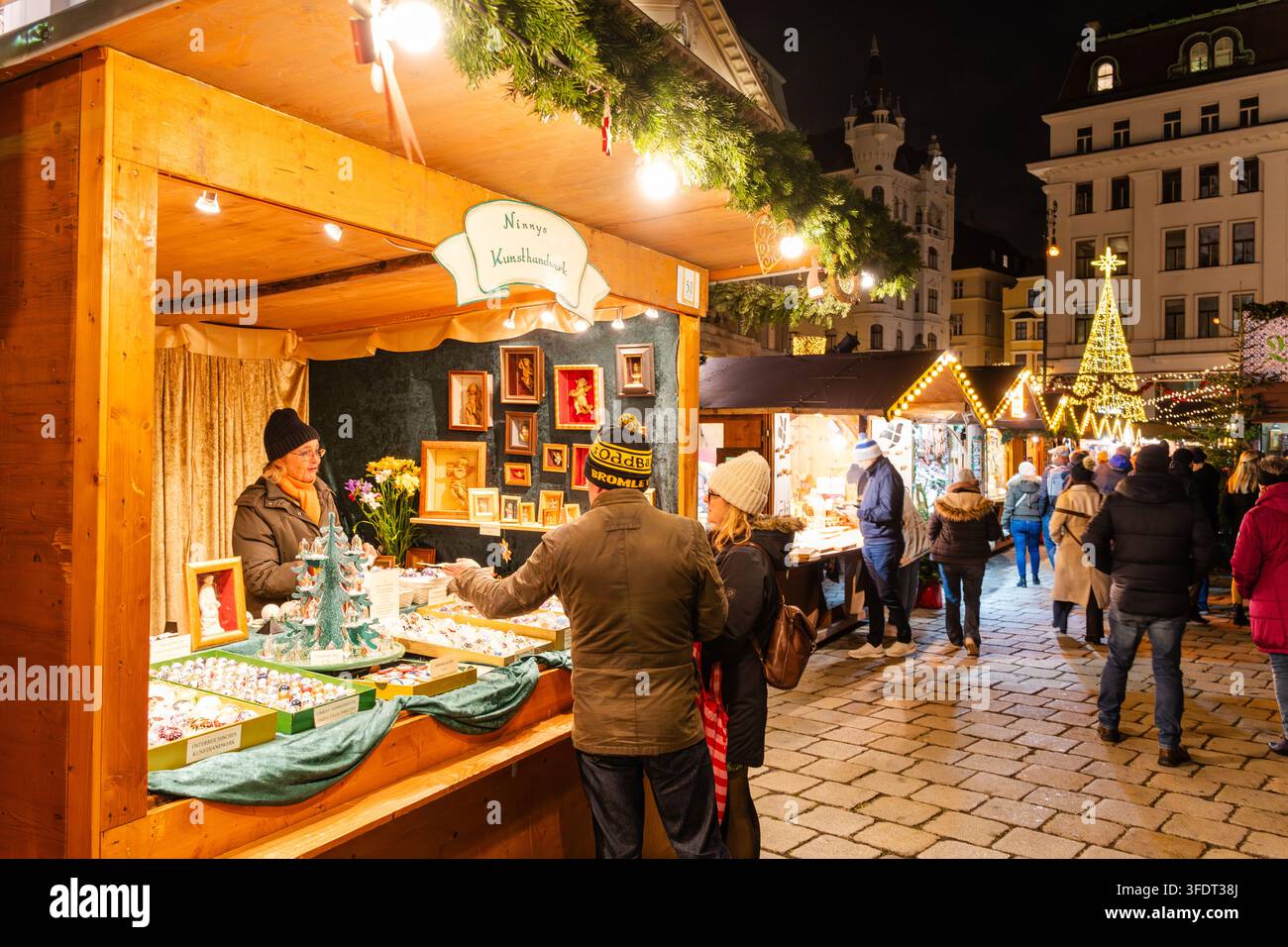 Weihnachtsmarkt (Weihnachtsmarkt am Hof) am Hofplatz in Wien, Österreich, mit beleuchteten Marktständen und Besuchern am Abend während des C Stockfoto