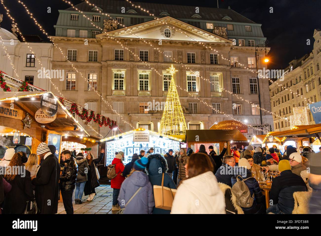 Weihnachtsmarkt (Weihnachtsmarkt am Hof) am Hofplatz in Wien, Österreich, mit beleuchteten Marktständen und Besuchern am Abend während des C Stockfoto