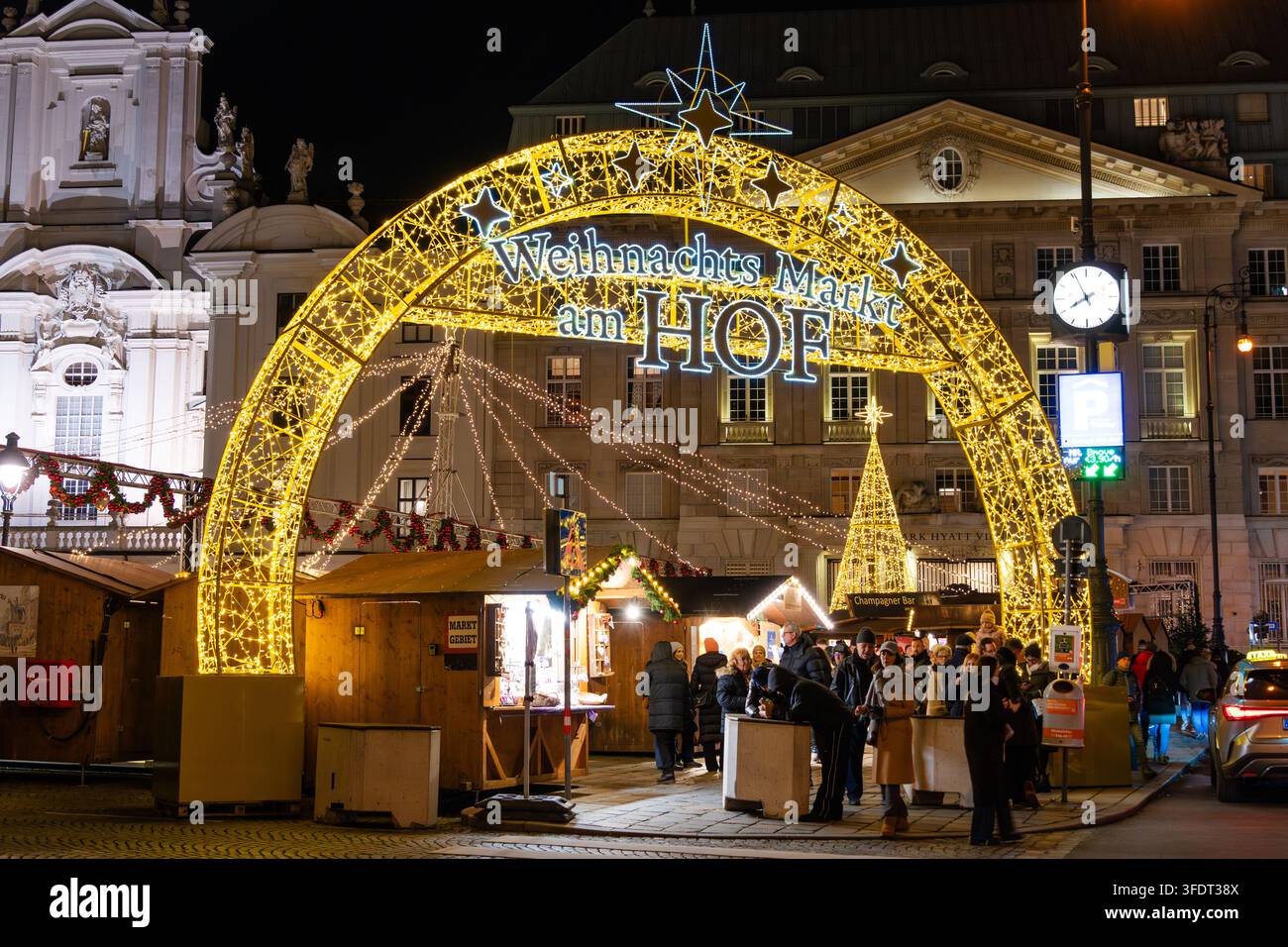 Weihnachtsmarkt (Weihnachtsmarkt am Hof) am Hofplatz in Wien, Österreich, mit beleuchteten Marktständen und Besuchern am Abend während des C Stockfoto
