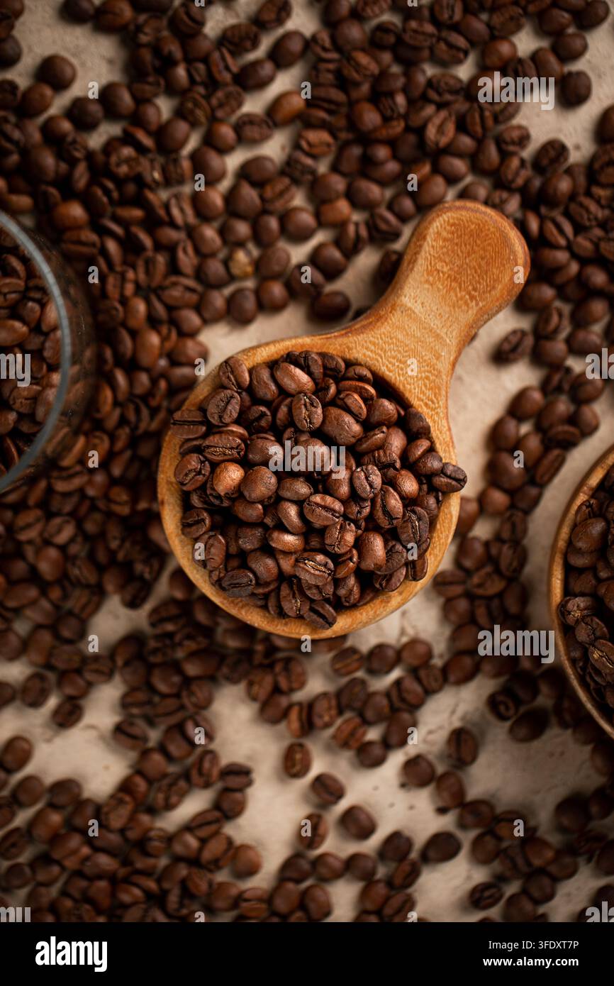 Geröstete Kaffeebohnen in einer Holzschaufel auf Stein Stockfoto