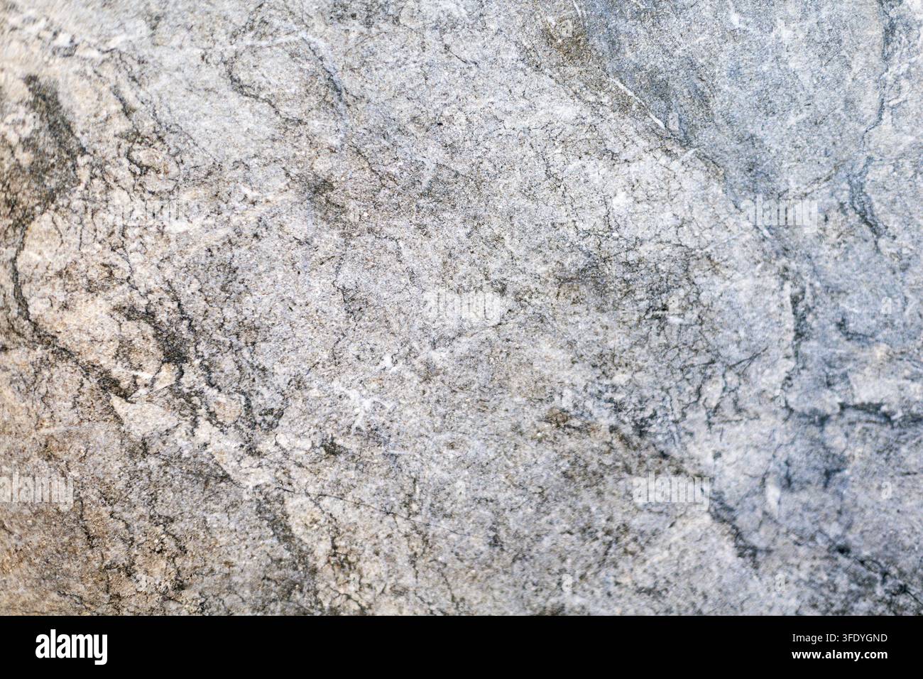 Graue Marmorsteintextur mit dunklen natürlichen Maserungen. Nahaufnahme von grauem Marmorstein mit dunklen Maserungen, gesprenkelten Details und natürlicher Mineraltextur. Stockfoto