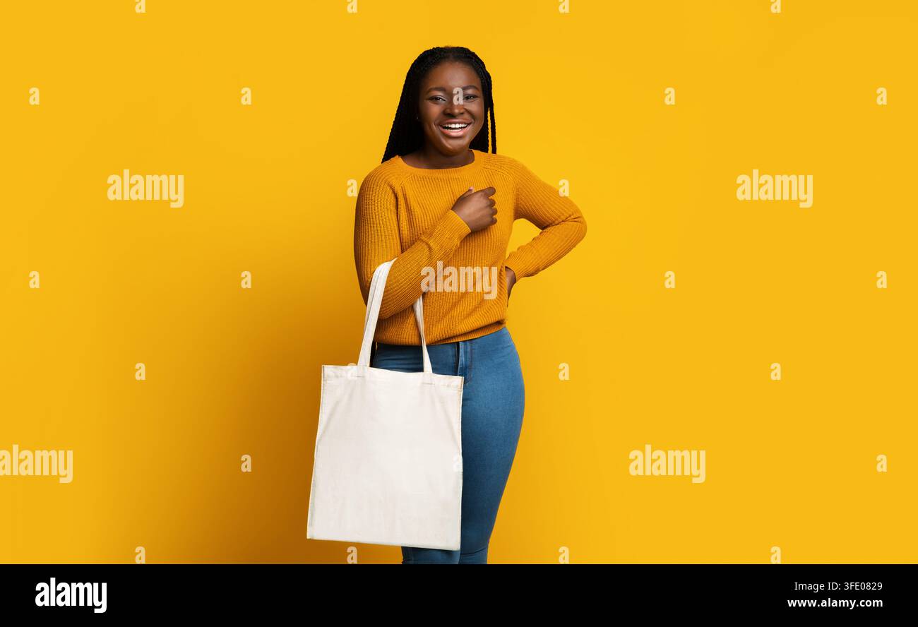 Modell Für Design. Fröhliche African American Lady Holding White Eco Tragetasche Stockfoto