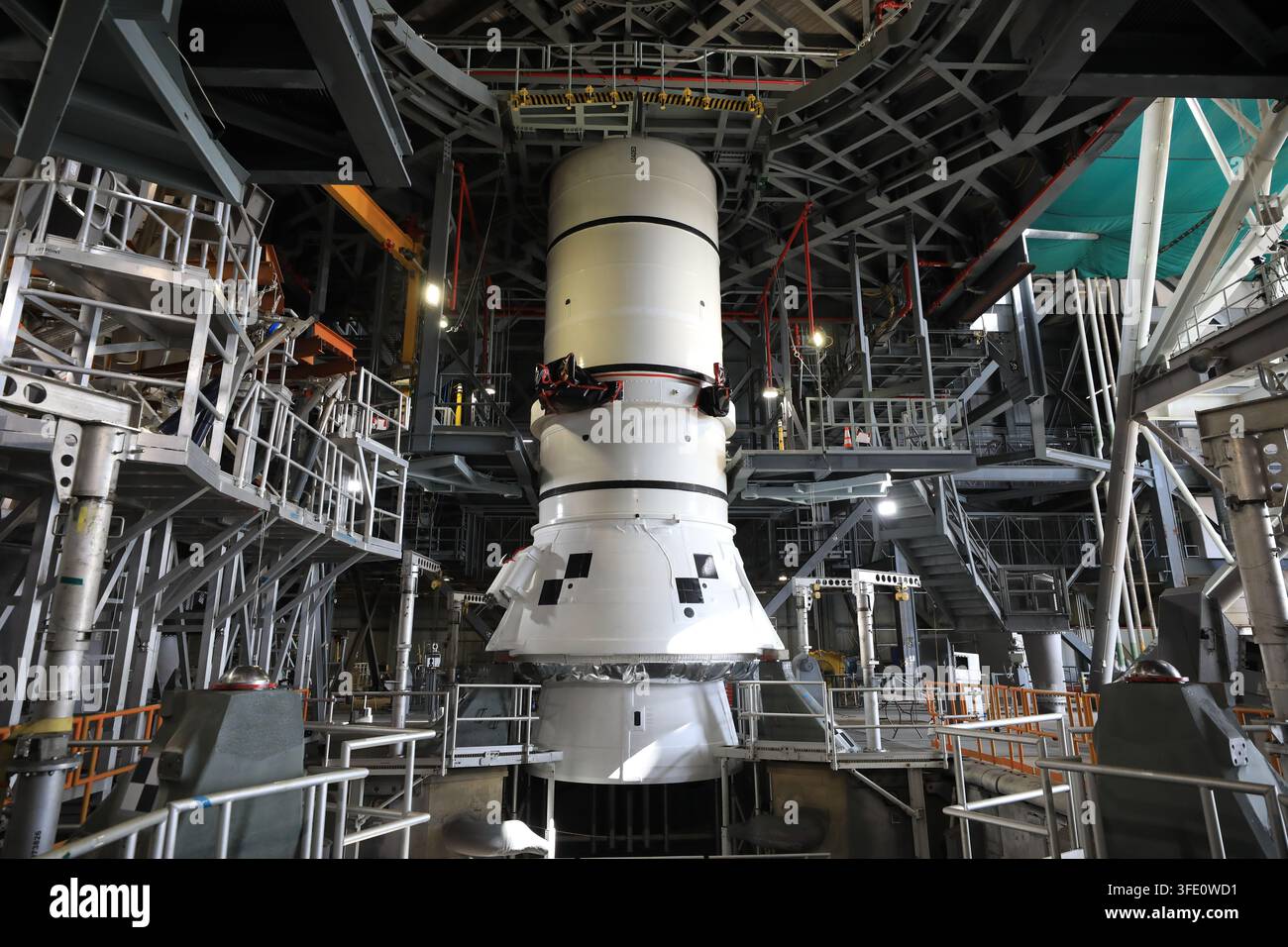 Der Raketenbooster des NASA-Artemis-III-Weltraumstartsystems (SLS) wird im Fahrzeugmontagegebäude des Kennedy Space Center in Florida gestapelt, wobei das linke Heckmontagefestes Raketenboostersegment gesichert wird, in Vorbereitung auf die Artemis-III-Mission zur Erprobung von Rendezvous- und Andockfähigkeiten für eine zukünftige Mondlandung. Stockfoto