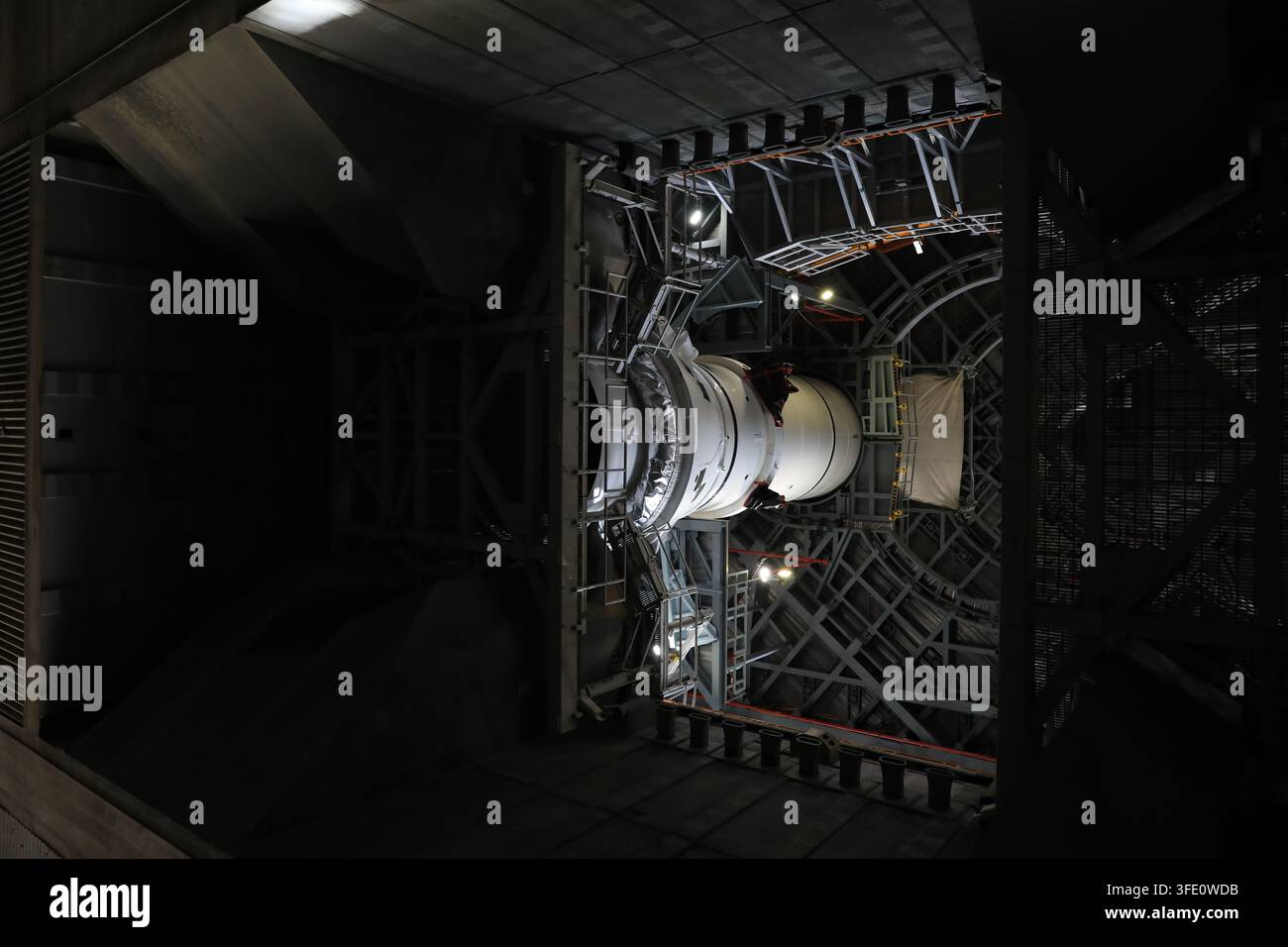 Der Raketenbooster des NASA-Artemis-III-Weltraumstartsystems (SLS) wird im Fahrzeugmontagegebäude des Kennedy Space Center in Florida gestapelt, wobei das linke Heckmontagefestes Raketenboostersegment gesichert wird, in Vorbereitung auf die Artemis-III-Mission zur Erprobung von Rendezvous- und Andockfähigkeiten für eine zukünftige Mondlandung. Stockfoto