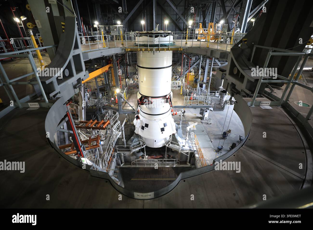 Der Raketenbooster des NASA-Artemis-III-Weltraumstartsystems (SLS) wird im Fahrzeugmontagegebäude des Kennedy Space Center in Florida gestapelt, wobei das linke Heckmontagefestes Raketenboostersegment gesichert wird, in Vorbereitung auf die Artemis-III-Mission zur Erprobung von Rendezvous- und Andockfähigkeiten für eine zukünftige Mondlandung. Stockfoto