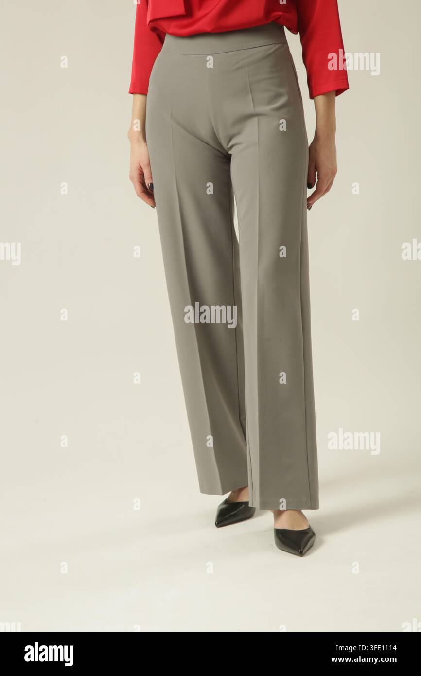 Modell trägt klassische maßgeschneiderte graue Hose mit seitlichem Reißverschluss, geeignet für Business Casual und professionelles Styling Stockfoto