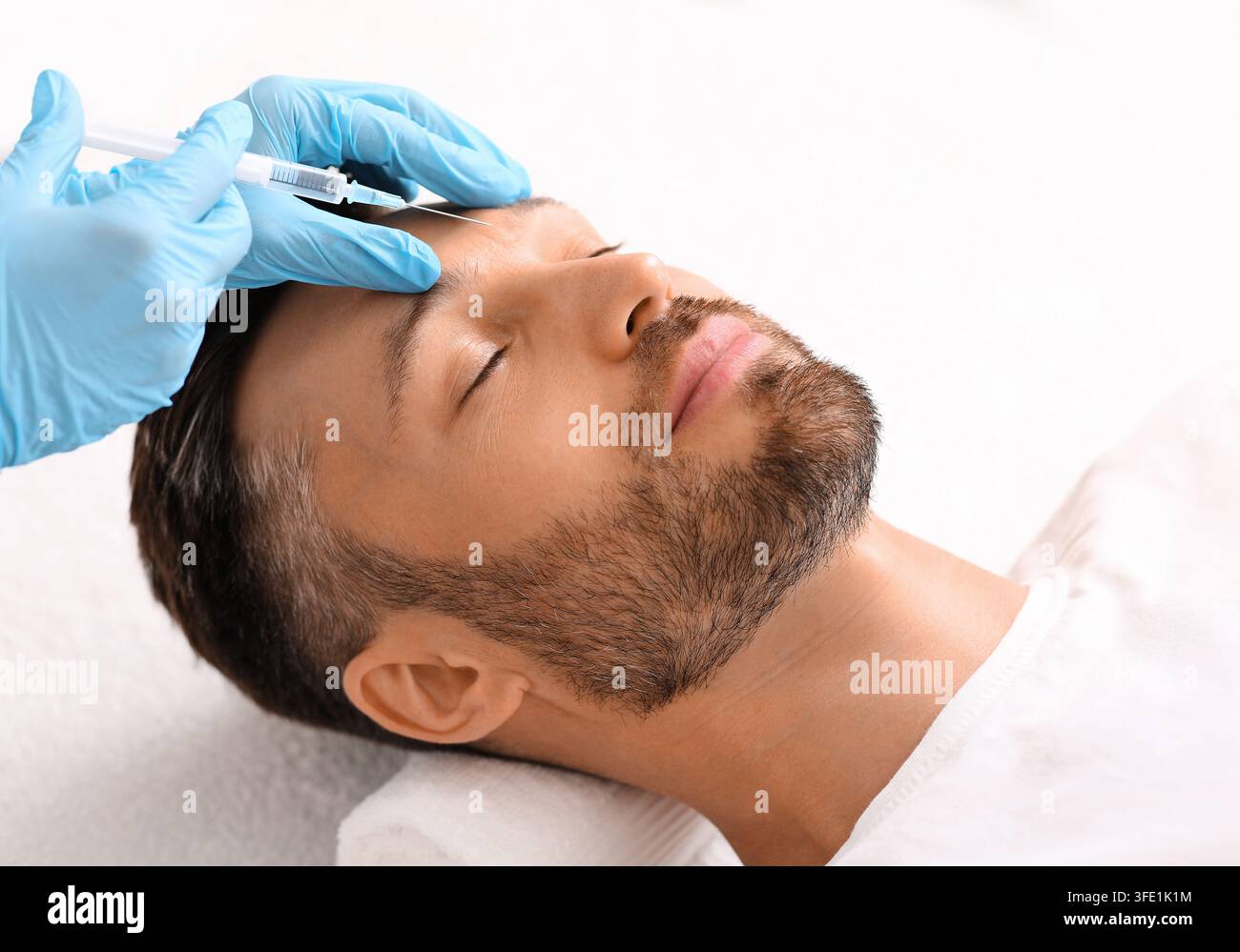 Kosmetologe Injektion Füllstoff zwischen Mann Brauen gegen Stirnrunzeln Stockfoto
