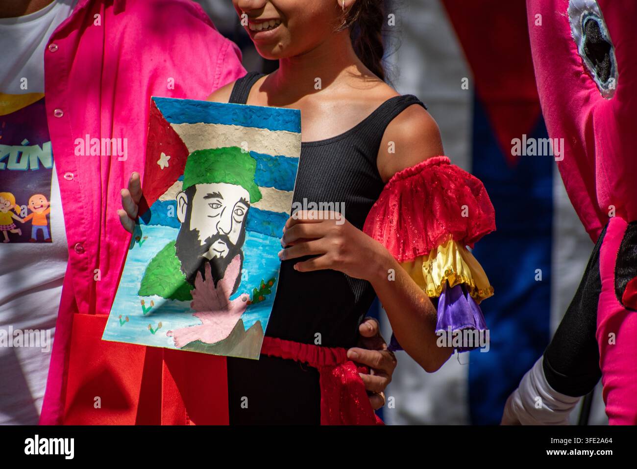 Junger Künstler hält eine Zeichnung von Fidel Castro und der kubanischen Flagge während des El Carnavalito-Events am 21. August 2026 in Ciego de Ávila, Kuba Stockfoto