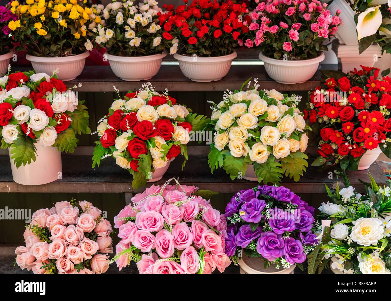 Bunte Kunstseidenblumenarrangements im Laden Stockfoto
