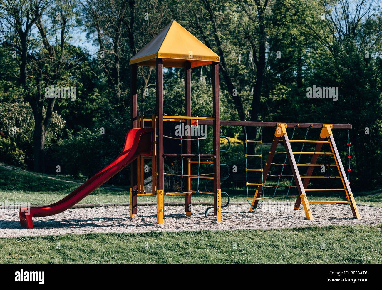 Kinderspielplatz mit roter Rutsche und Klettergerüst Stockfoto