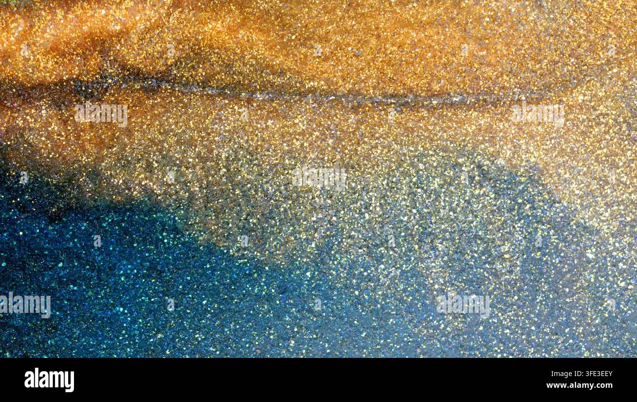 Der Prozess des Mischens von Alkohol-Tinte erzeugt lebendige Muster und Farben. Gold und Blau wirbeln in einer künstlerischen Darstellung zusammen, reflektieren Licht und enthüllen Stockfoto