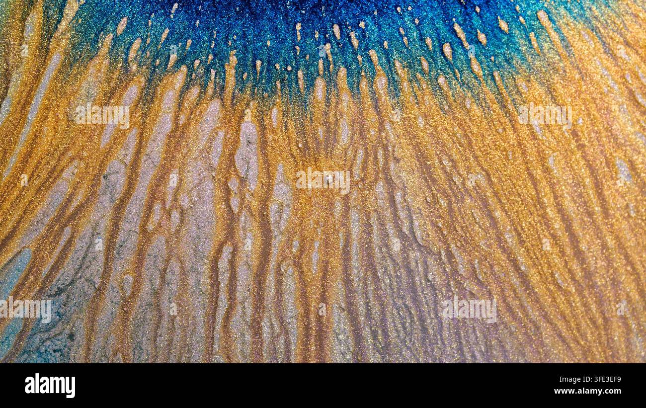 Fragmente von Alkohol-Tinte, die miteinander vermischt werden. Die Farben vermischen sich und bilden Muster, während die Tinte mit der Oberfläche interagiert. Die Mischung erfolgt im Innenraum während Stockfoto
