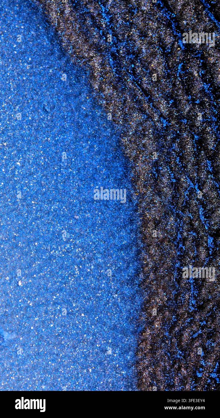 Das Bild zeigt die Nahaufnahme von Alkohol-Tinte, die sich vermischt. Die blaue Tinte verschmilzt mit dunklen Tönen und erzeugt eine Reihe von Texturen und Mustern. Dies geschieht Stockfoto