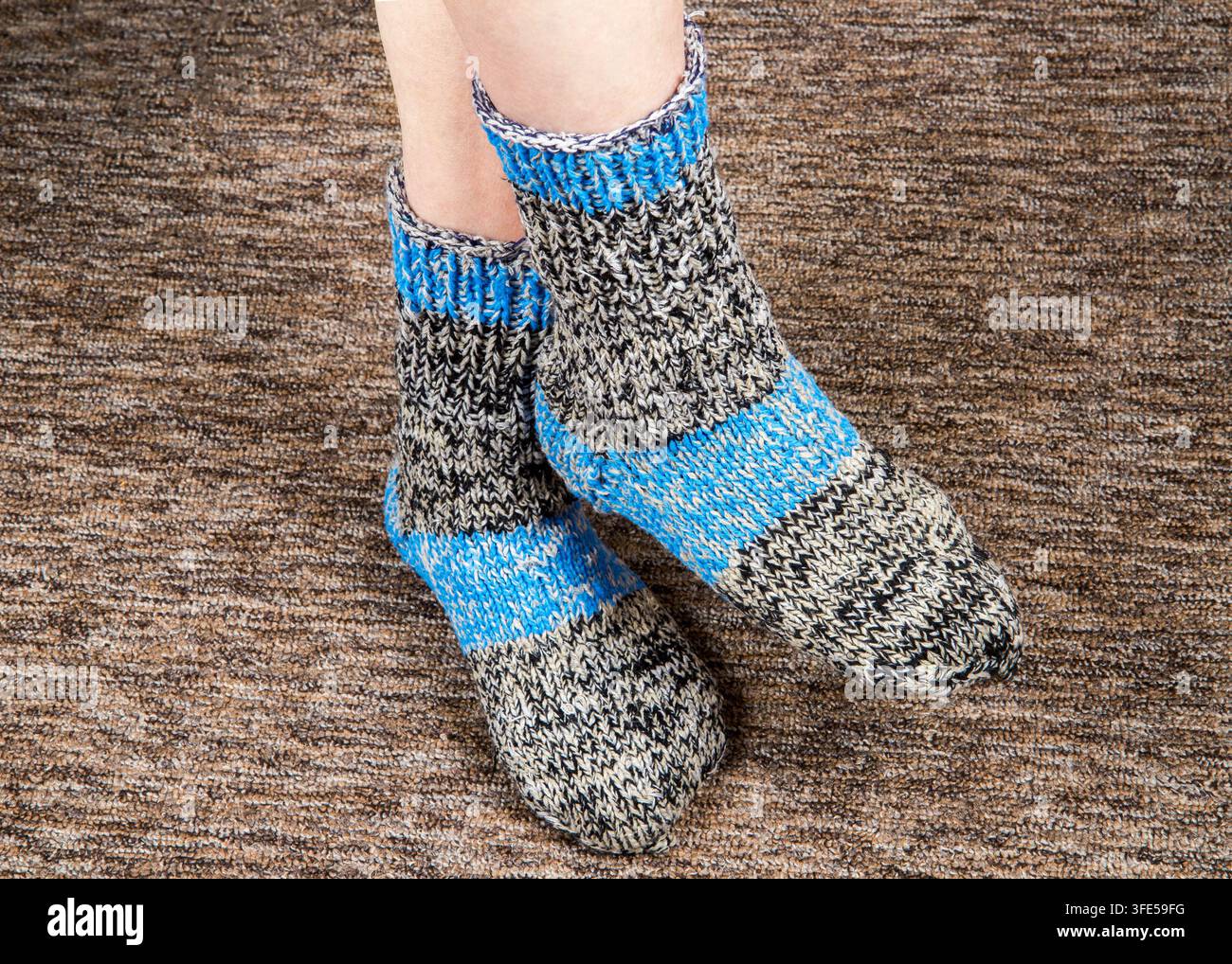 Füße in gestrickten Wollsocken. Warme hausgemachte Socken Stockfoto