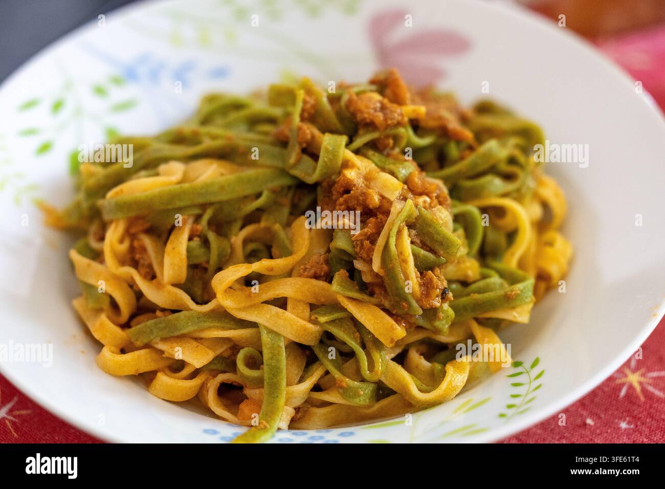 Authentische hausgemachte zweifarbige Tagliatelle mit reichhaltiger Fleischsauce Stockfoto