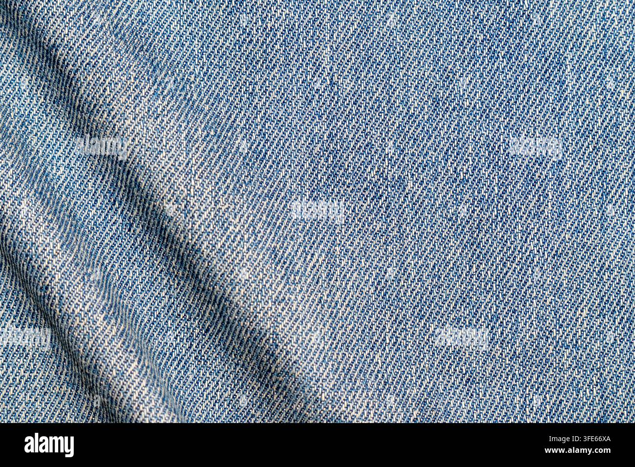 Oberansicht von hellblauer Denimjeans-Textur mit subtilen Falten und diagonalem Köpergewebe-Muster. Nahtloser textile Hintergrund, ideal Stockfoto