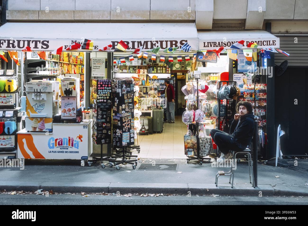 Lebhafte Straßenszene an einem französischen Supermarkt mit umfangreichen Außenvitrinen und zahlreichen Werbeschildern, Paris, Île-de-France, Frankreich Stockfoto