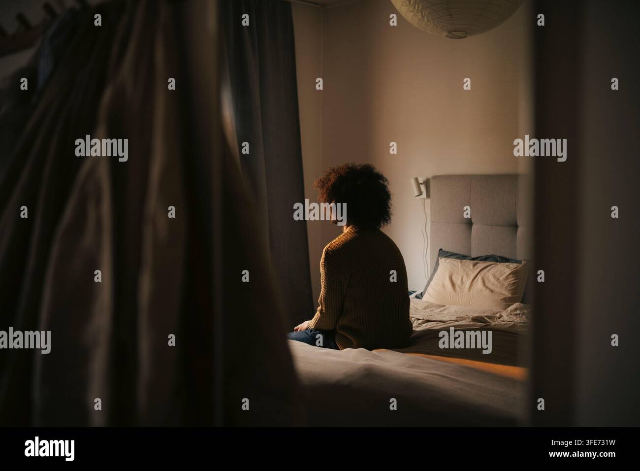 Deprimierter Mann sitzt allein im Schlafzimmer zu Hause Stockfoto