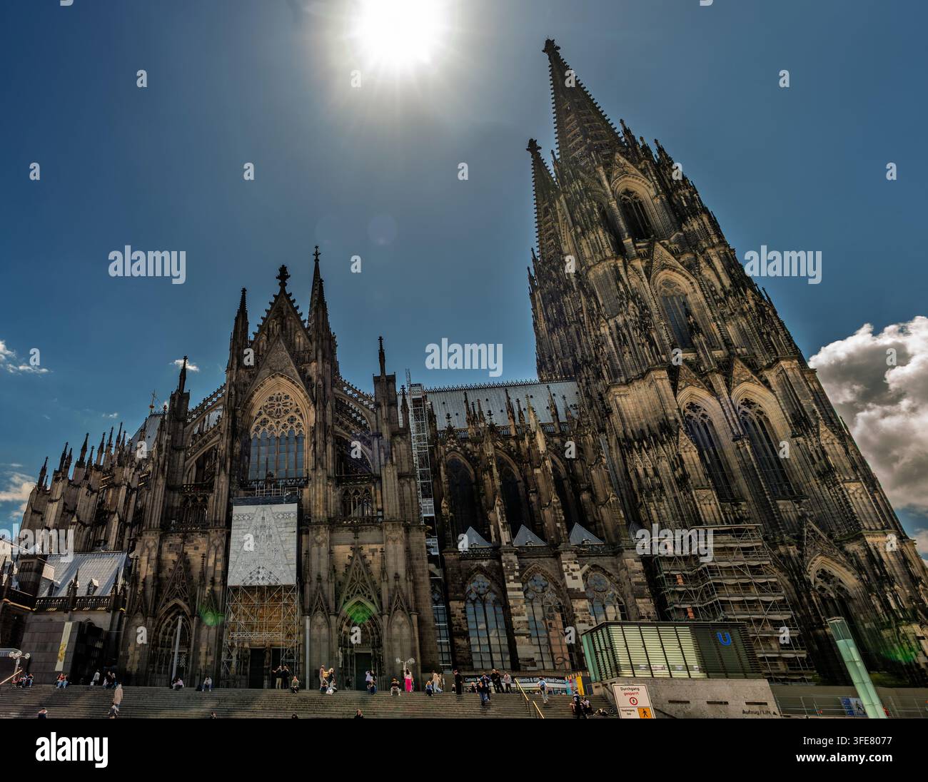 Köln, Deutschland – Juni 2026: Besucher versammeln sich auf den Stufen des Kölner Doms unter seinen hoch aufragenden gotischen Türmen. Stockfoto