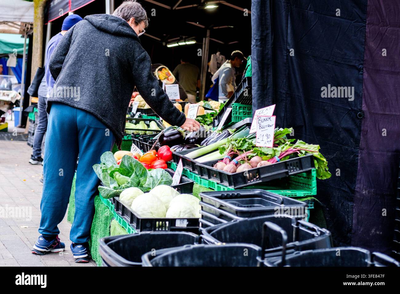 London, UK, 03. September 2026, Frau wählt frische Bio-Gemüse auf einem lokalen UK-Straßenmarktstand Stockfoto