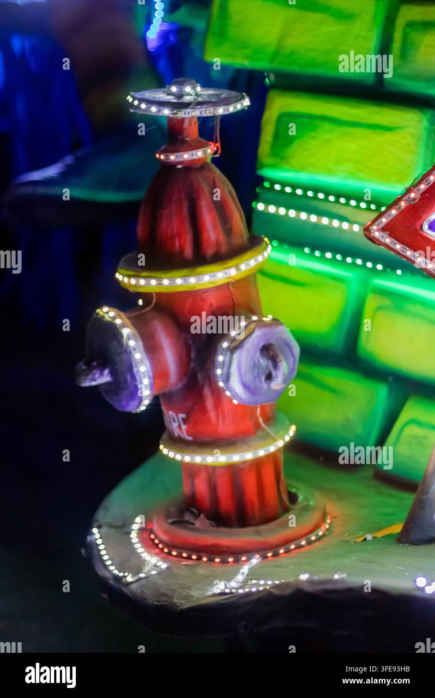 Marsaskala, Malta - 23. August 2026, Bunte beleuchtete Feuerhydrant-Feierdekoration mit LED-Lichtern und festlichem grünem Hintergrund Stockfoto