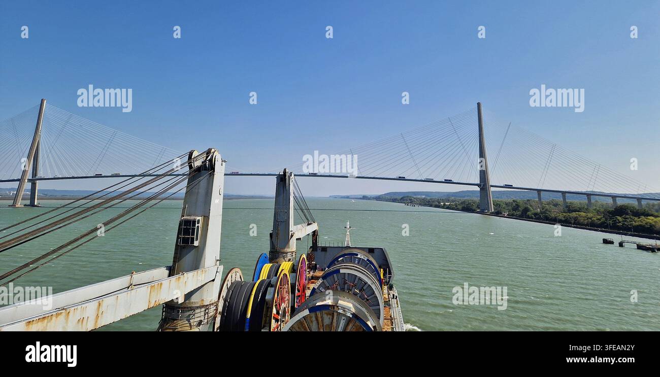 Hochwinkelaufnahme eines kommerziellen Öltankers, begleitet von einem Schleppboot, das durch offene Gewässer navigiert Stockfoto