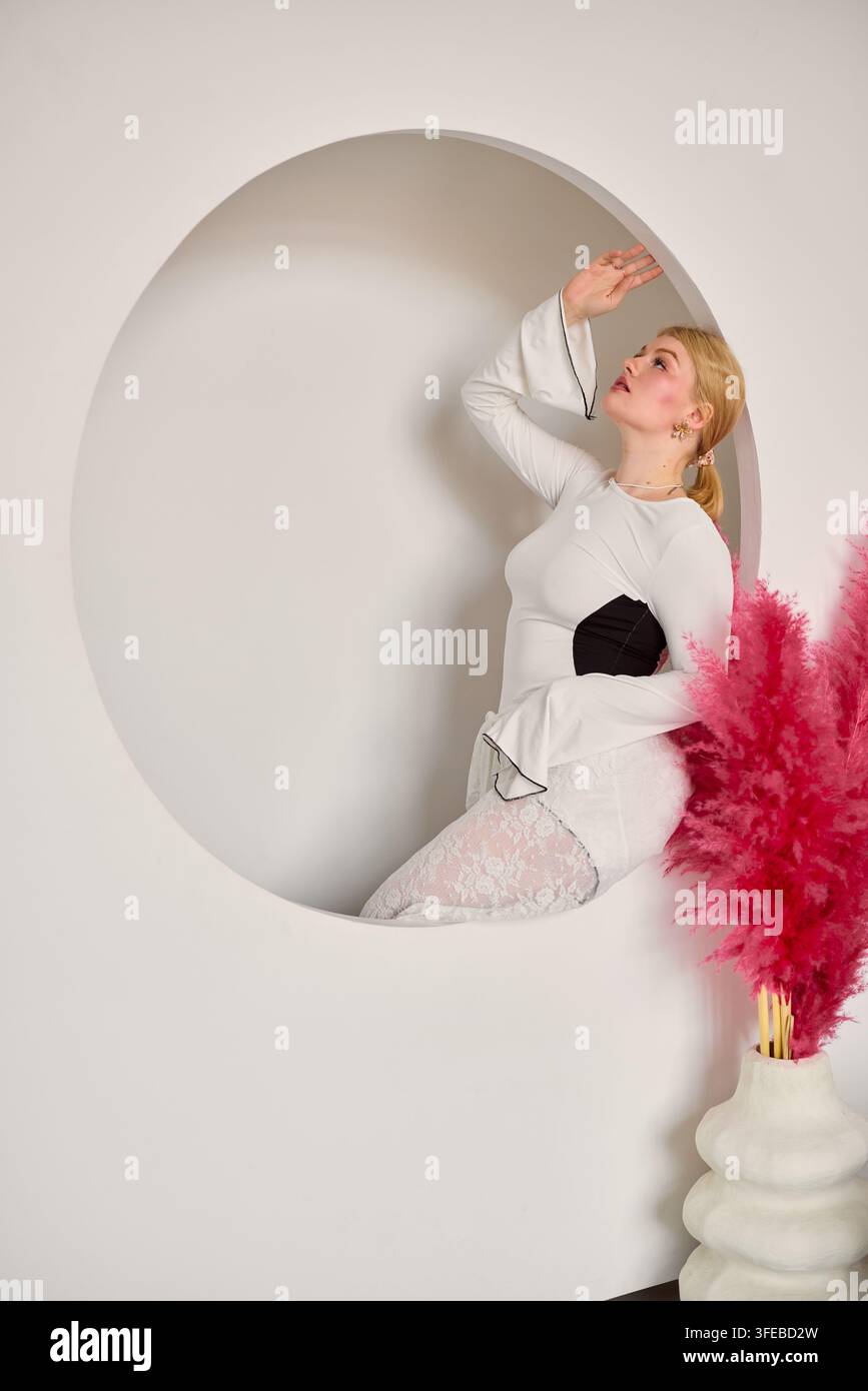Stilvolles Model posiert graziös mit gedämpften Farben und Texturen Stockfoto