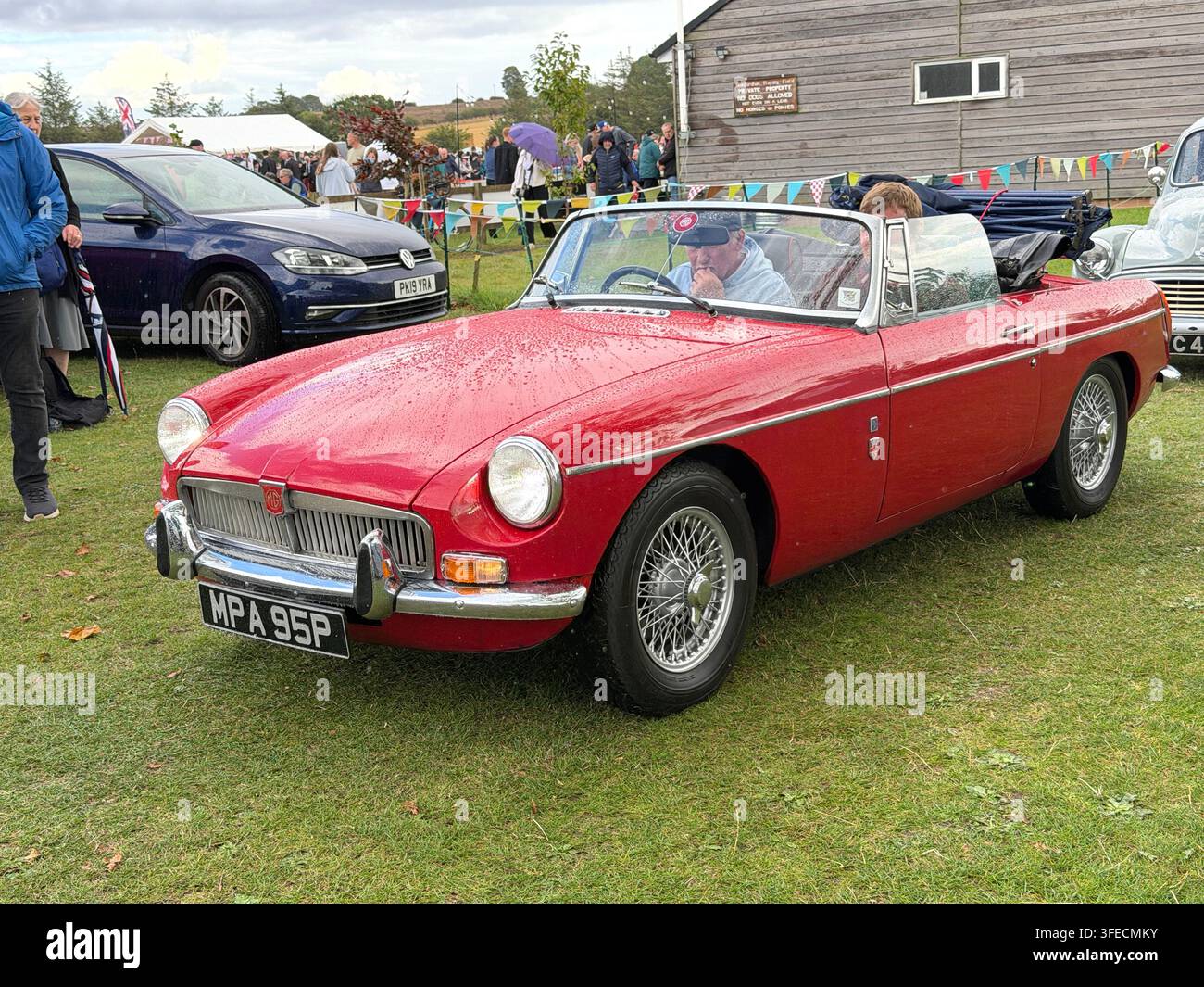 Vintage rotes Classic MG MGB Cabriolet auf einer Oldtimerschau in einer Außenumgebung mit anderen Autos und Besuchern in der Nähe Stockfoto