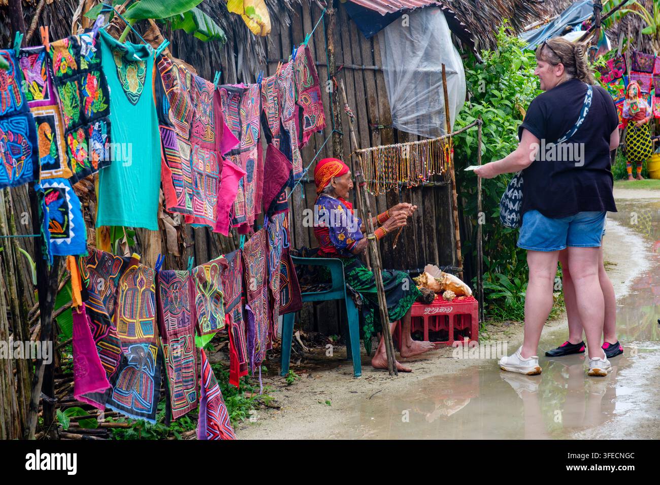 Frau der Kuna Yala verkauft Molas und andere Handarbeiten an Touristen vor einem Stammeshaus in Comarca Guna Yala, San-Blas-Inseln, Panama Stockfoto