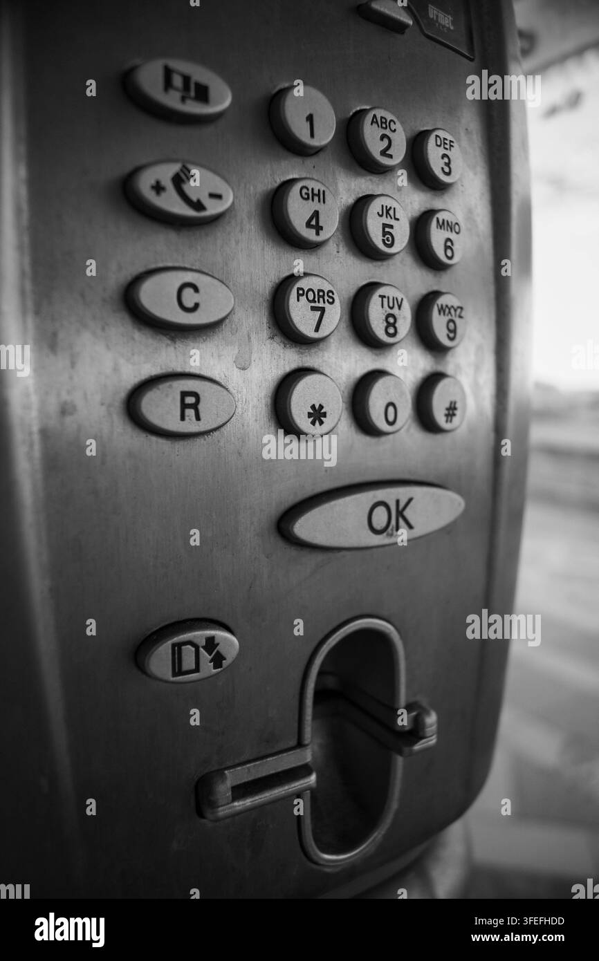 Schwarz-Weiß-Nahaufnahme eines Metall-Tastaturfeldes mit nummerierten Tasten und einem Schlüssel, der in das Schloss gesteckt ist. Stockfoto